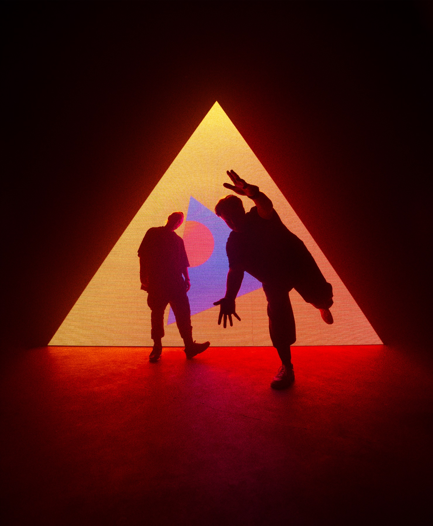 Tritonal standing in front of a triangular stage light