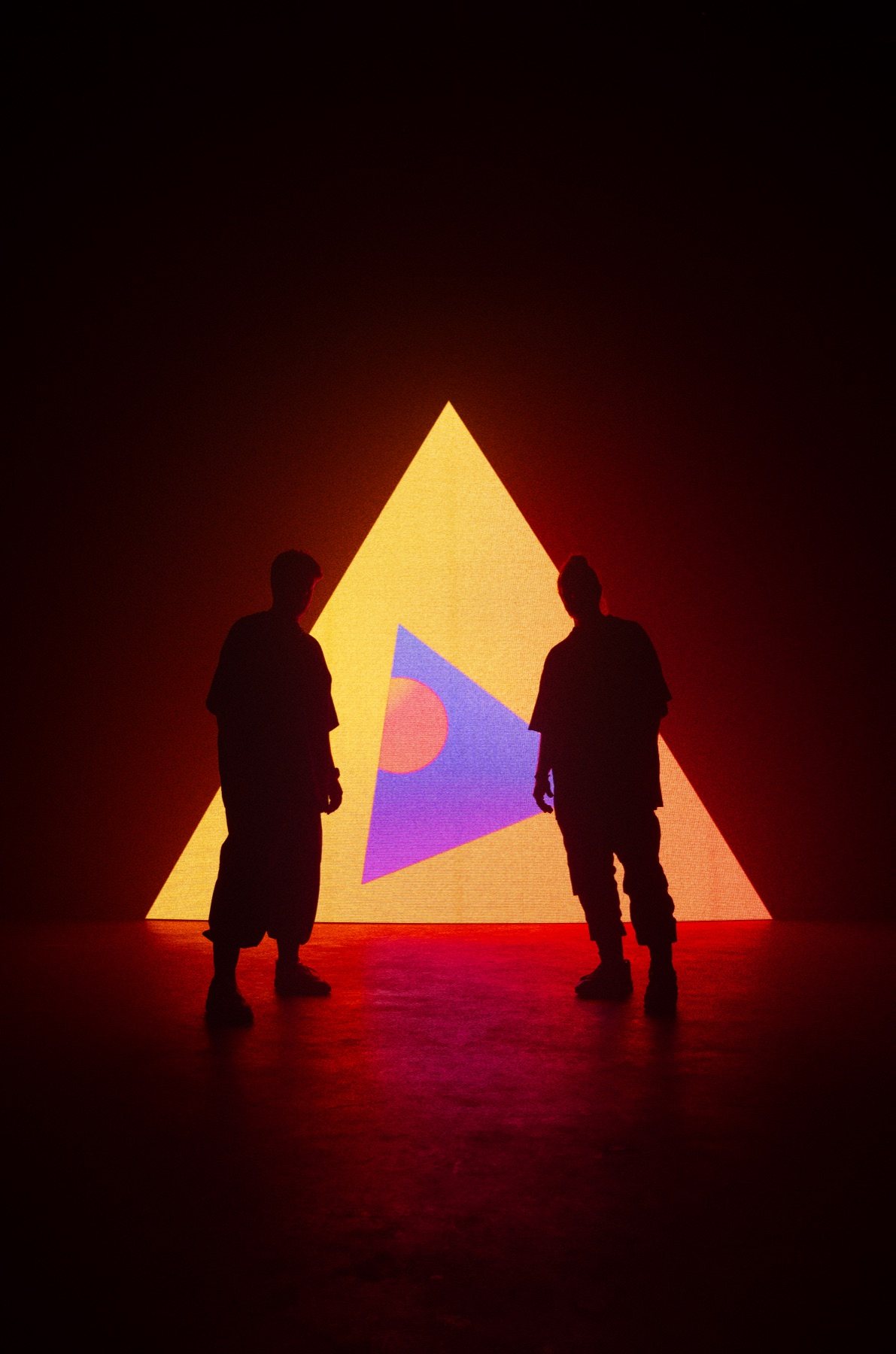 Tritonal silhouettes in front of a glowing triangle visual